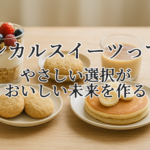 植物由来の材料で作られたエシカルスイーツ。自然光の中で並ぶパフェ、プリン、クッキー、パンケーキが温かみのある木のテーブルに置かれている写真。