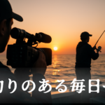 夕日を背景に、船上でカメラマンがアングラーの実釣シーンを撮影している様子