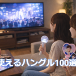 K-POPのライブ映像をテレビで見ながらグッズを持って楽しむ若い女性2人の様子