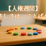 人権週間をテーマに、木製の机の上で色とりどりのチップが円形に並ぶ、教室をイメージした優しい写真