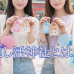 推し色のお守りと絵馬を手に、神社で推し活を楽しむ若い女性2人の様子