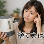 古くなった電気ケトルを手に、捨て方に悩む女性の様子