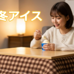 こたつに入りながらアイスを食べる若い女性の様子。冬に人気の“冬アイス”を楽しむシーン