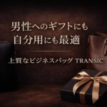 男性へのギフトにも自分用にも最適なTRANSICの上質ビジネスバッグ。ブラックとブラウンの本革バッグとギフトボックスを並べた上品なイメージ