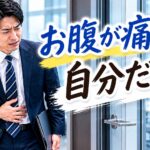 会議室の前でお腹を押さえる男性サラリーマン