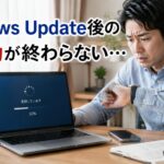 再起動が終わらないPCの前で困惑する男性