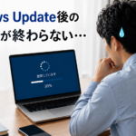 再起動が終わらないPCの前で困惑する男性