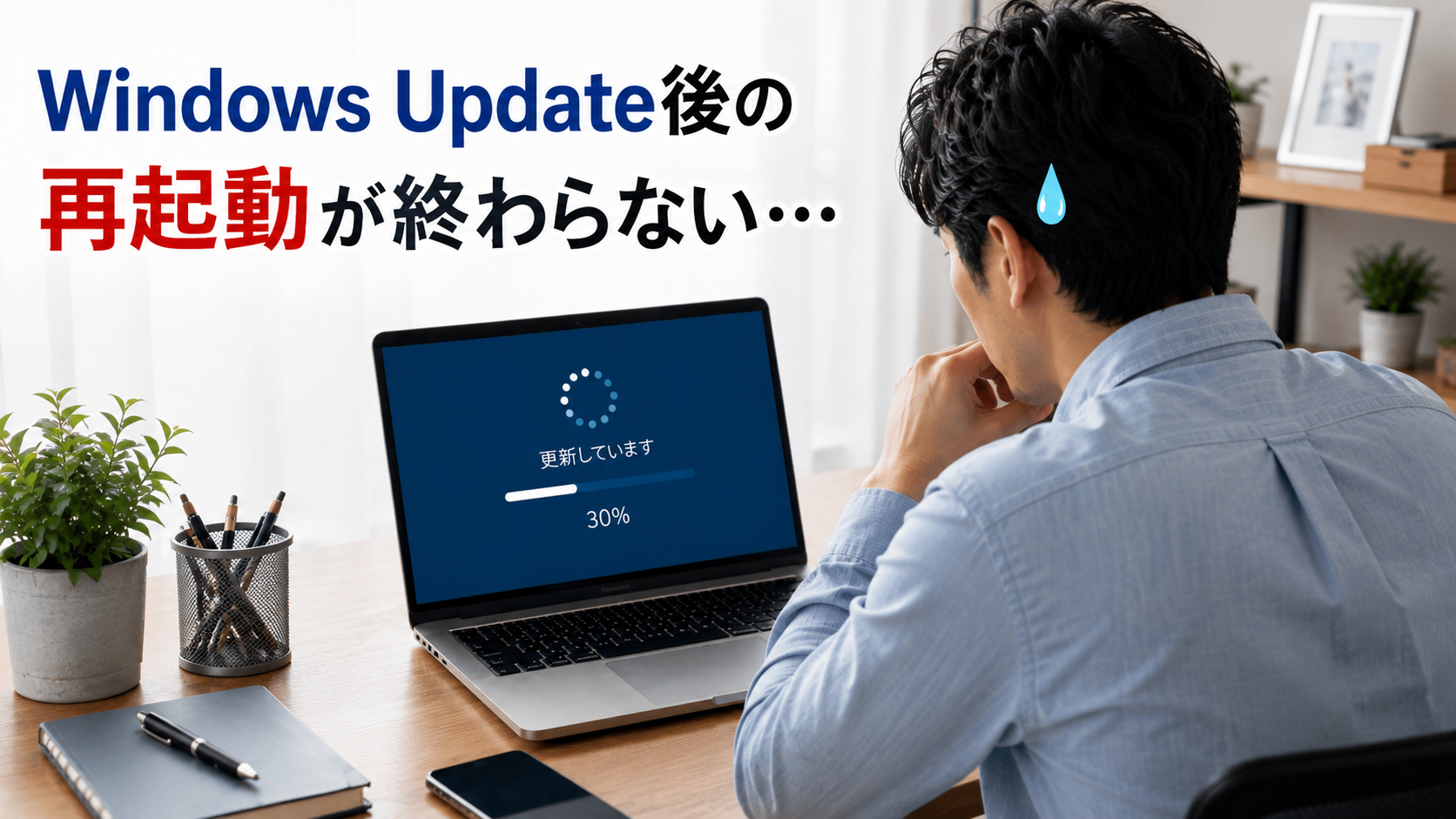 再起動が終わらないPCの前で困惑する男性